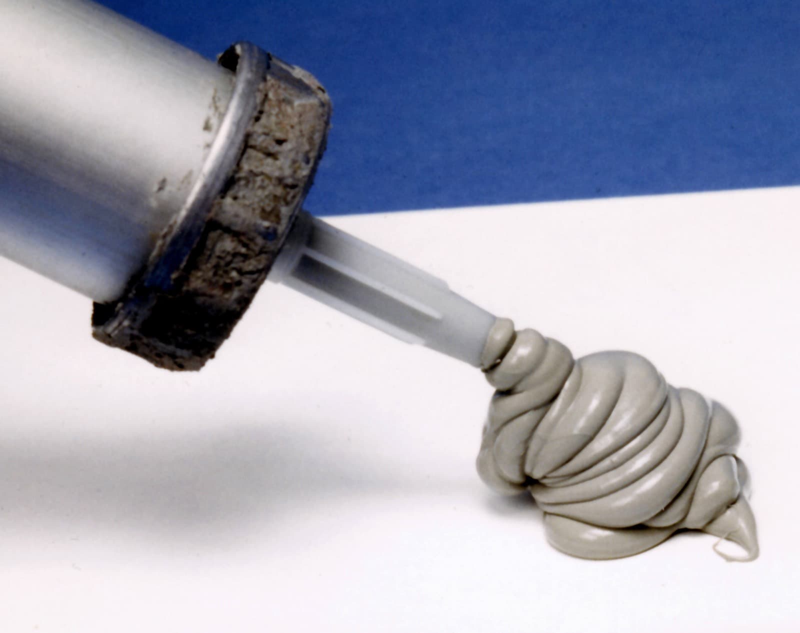 Caulking gun dispensing grey sealant during finishing work