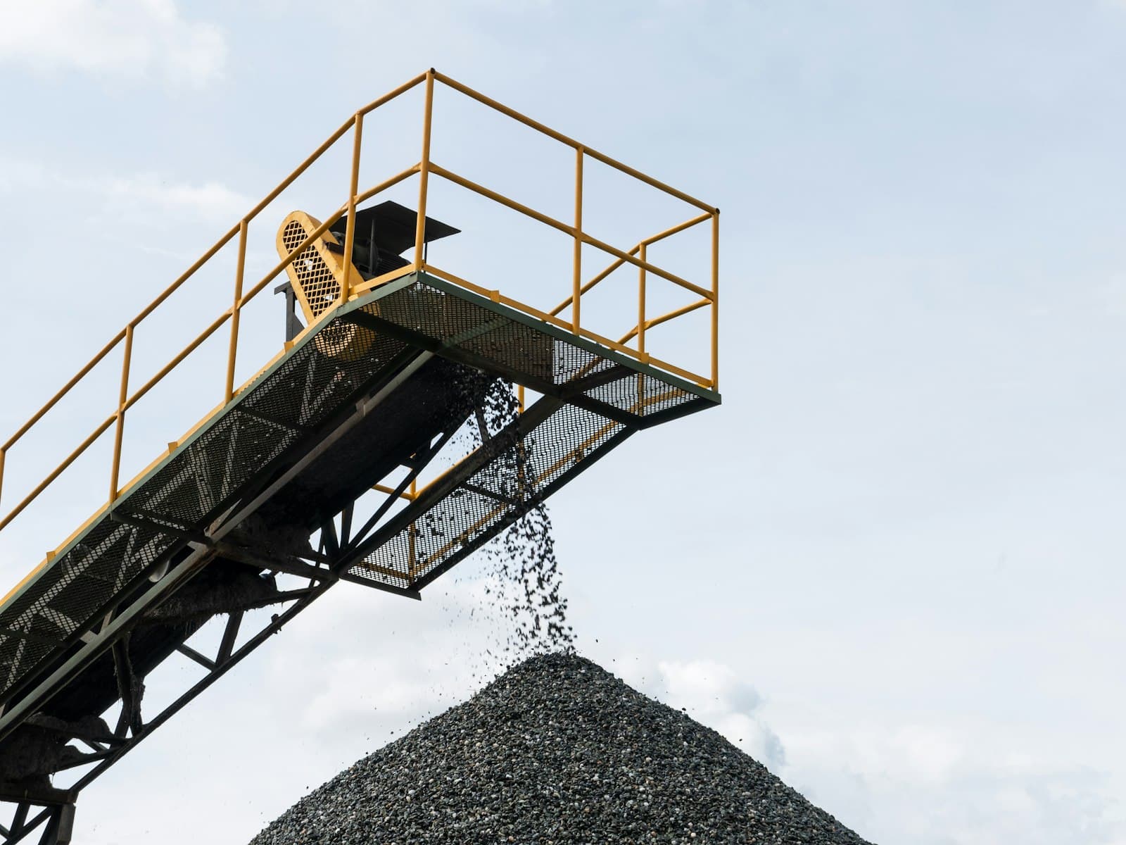 Conveyor loading a pile of crushed stone aggregate at a quarry