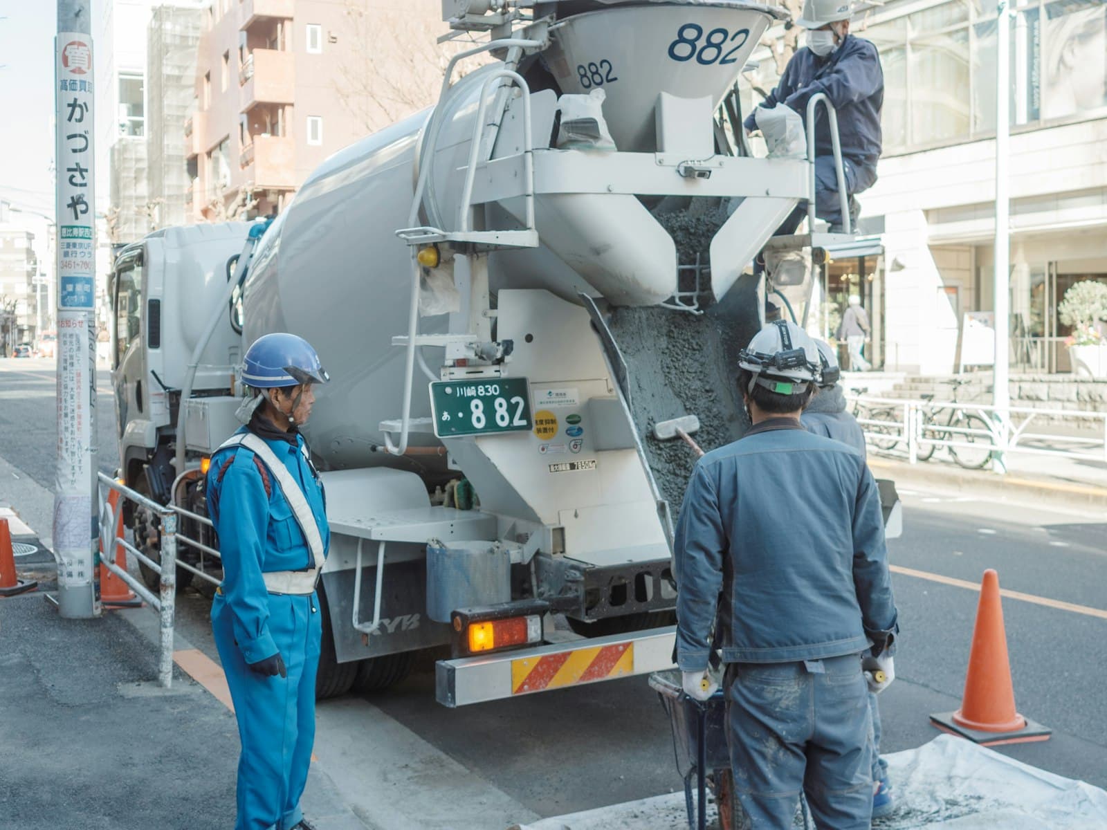 Crew pouring ready-mix concrete from a transit mixer on site