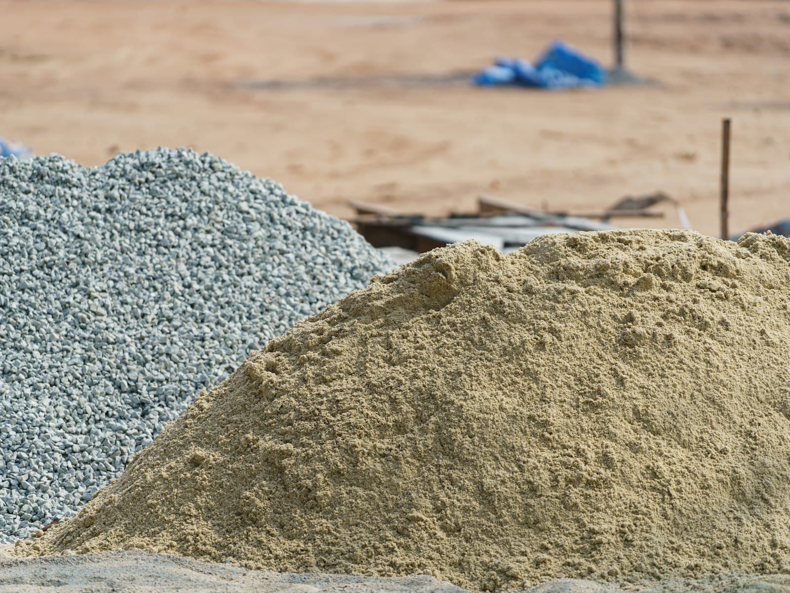 Piles of construction sand and crushed gravel on a building site