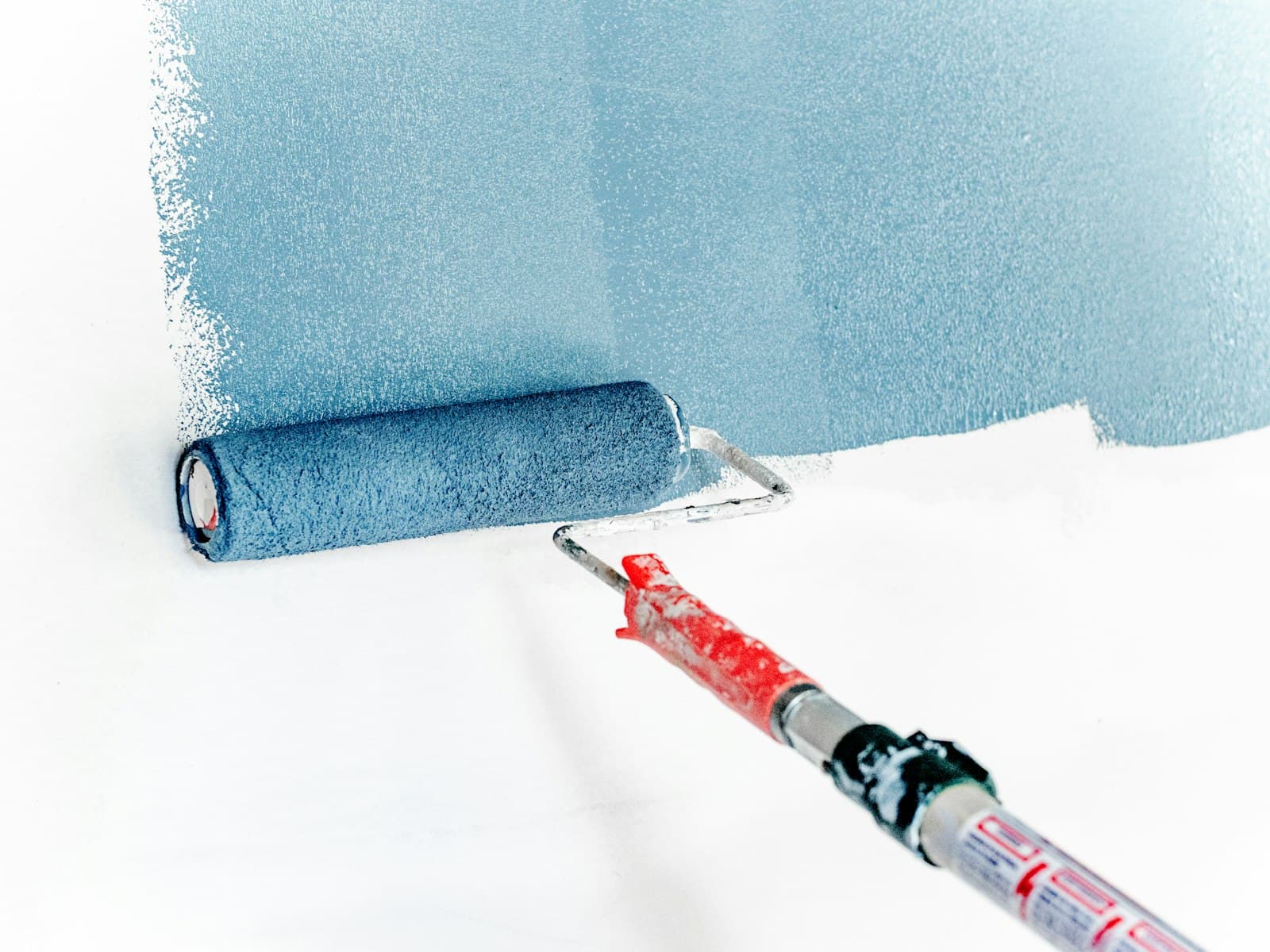 Paint roller applying a waterproof coating to a wall surface